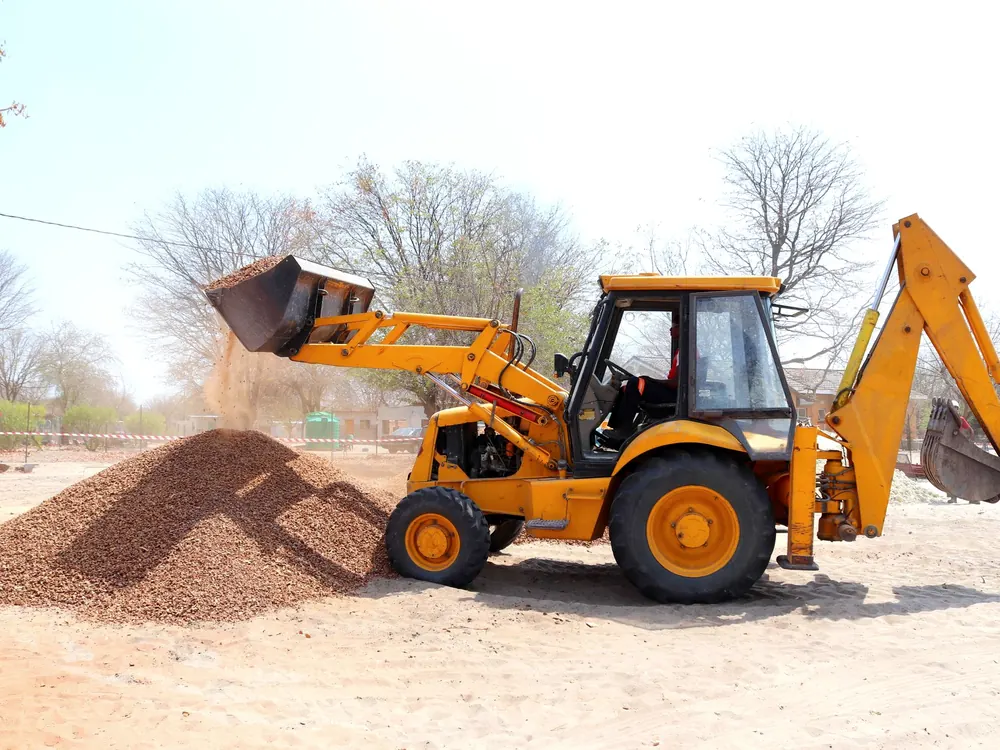 Loader spreading fresh gravel for a new driveway
